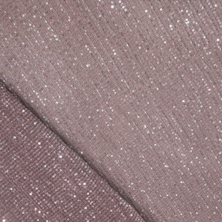 Close-up of a fabric with glittery sequins on a brown background