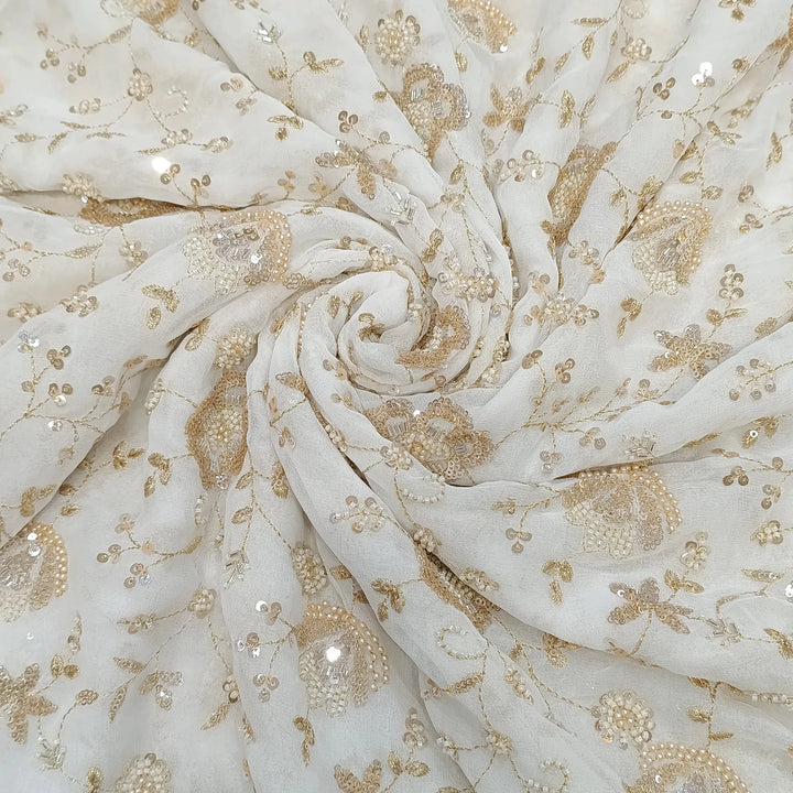 White fabric with gold floral embroidery and sequins