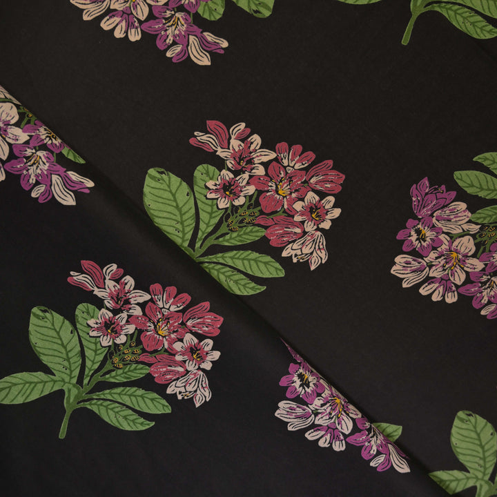 Floral pattern with pink and green flowers on a black cotton fabric