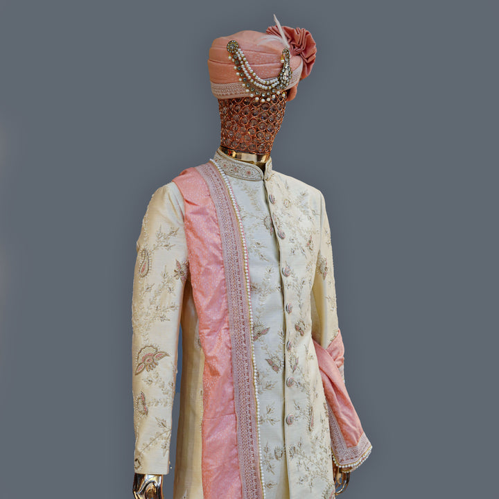 Traditional embroidered outfit with pink accents on a gray background