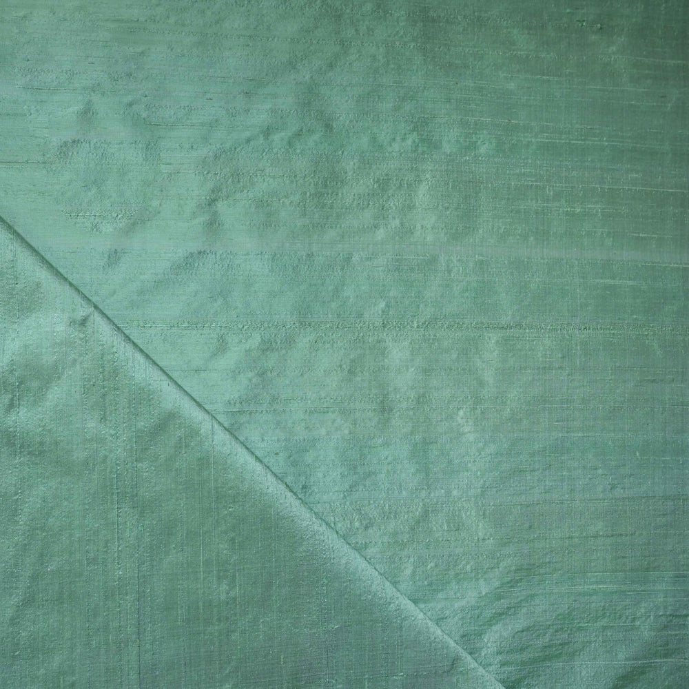 Green fabric texture with a diagonal seam