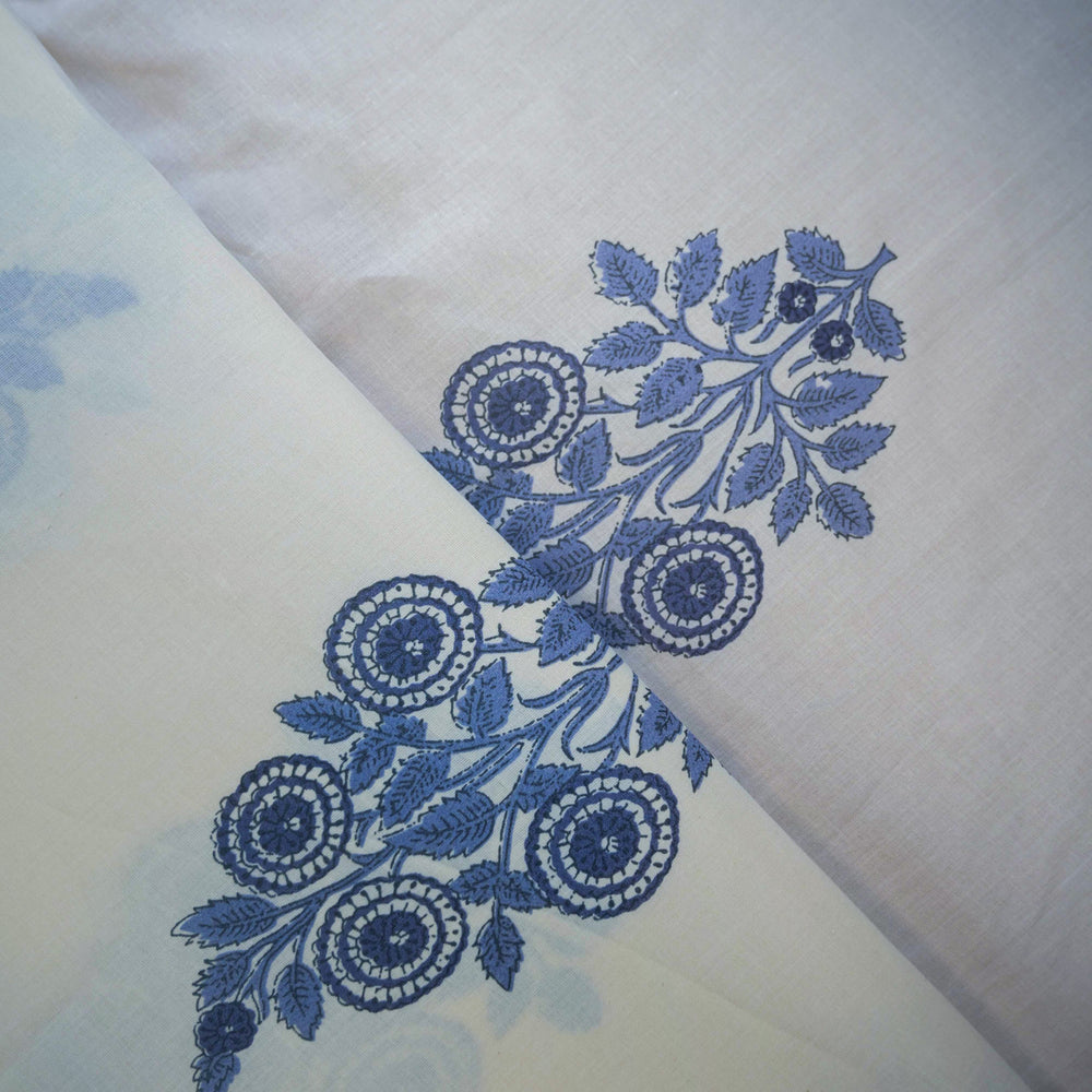 White fabric with blue floral embroidery on a light background
