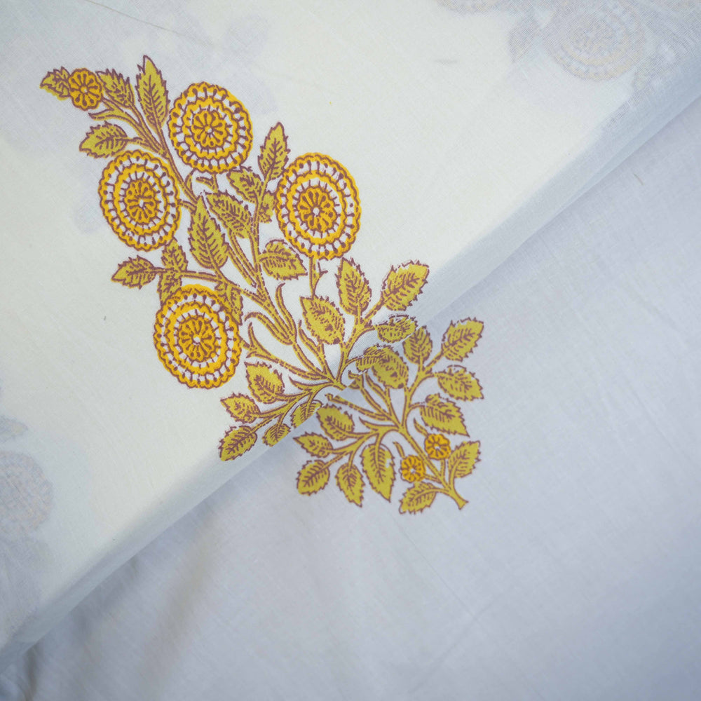 Yellow floral embroidery on a white cotton fabric