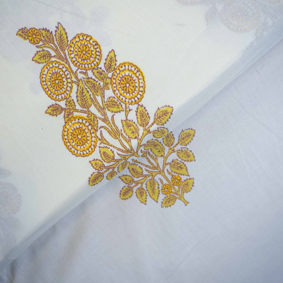 Yellow floral embroidery on a white cotton fabric