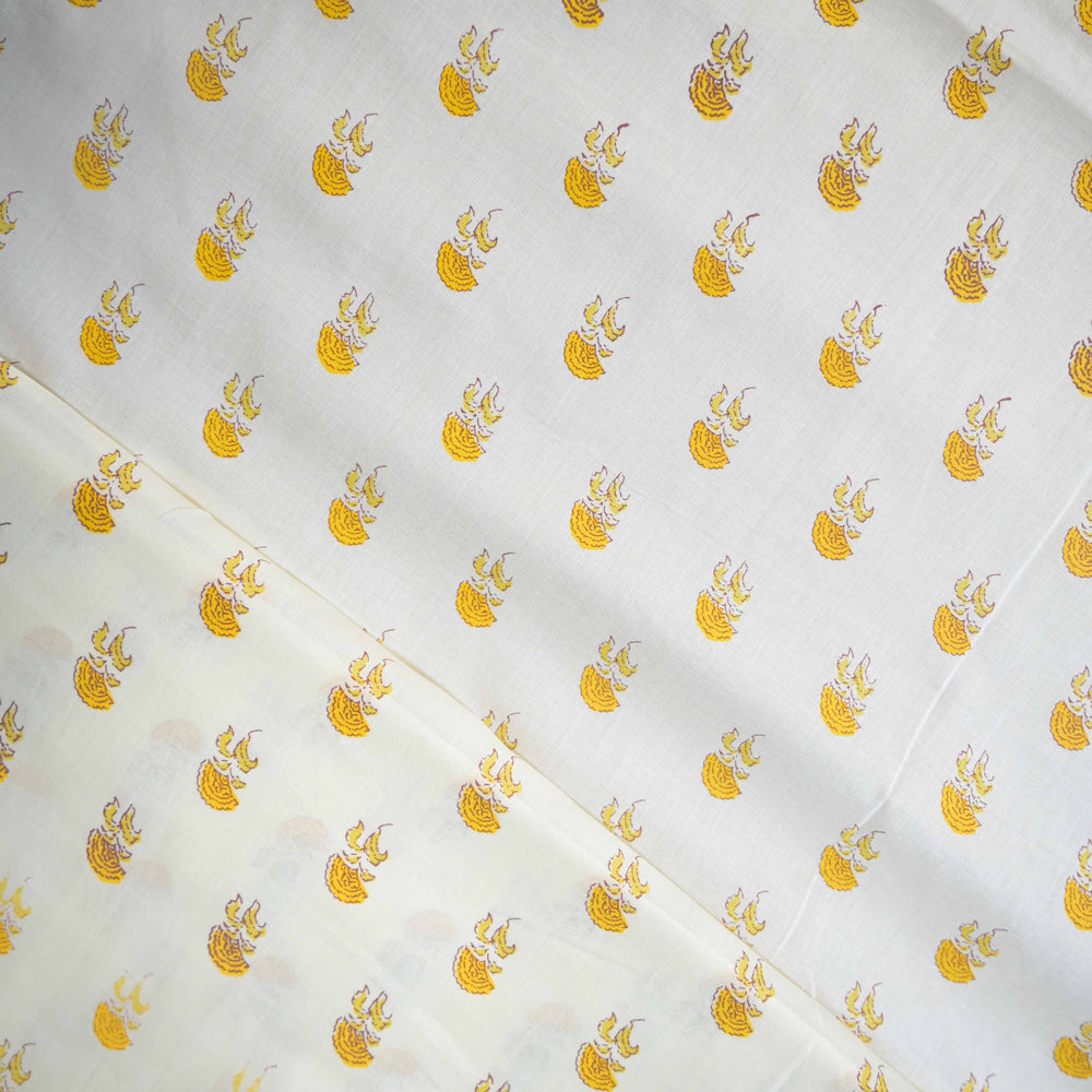 White fabric with yellow floral patterns arranged in a grid.