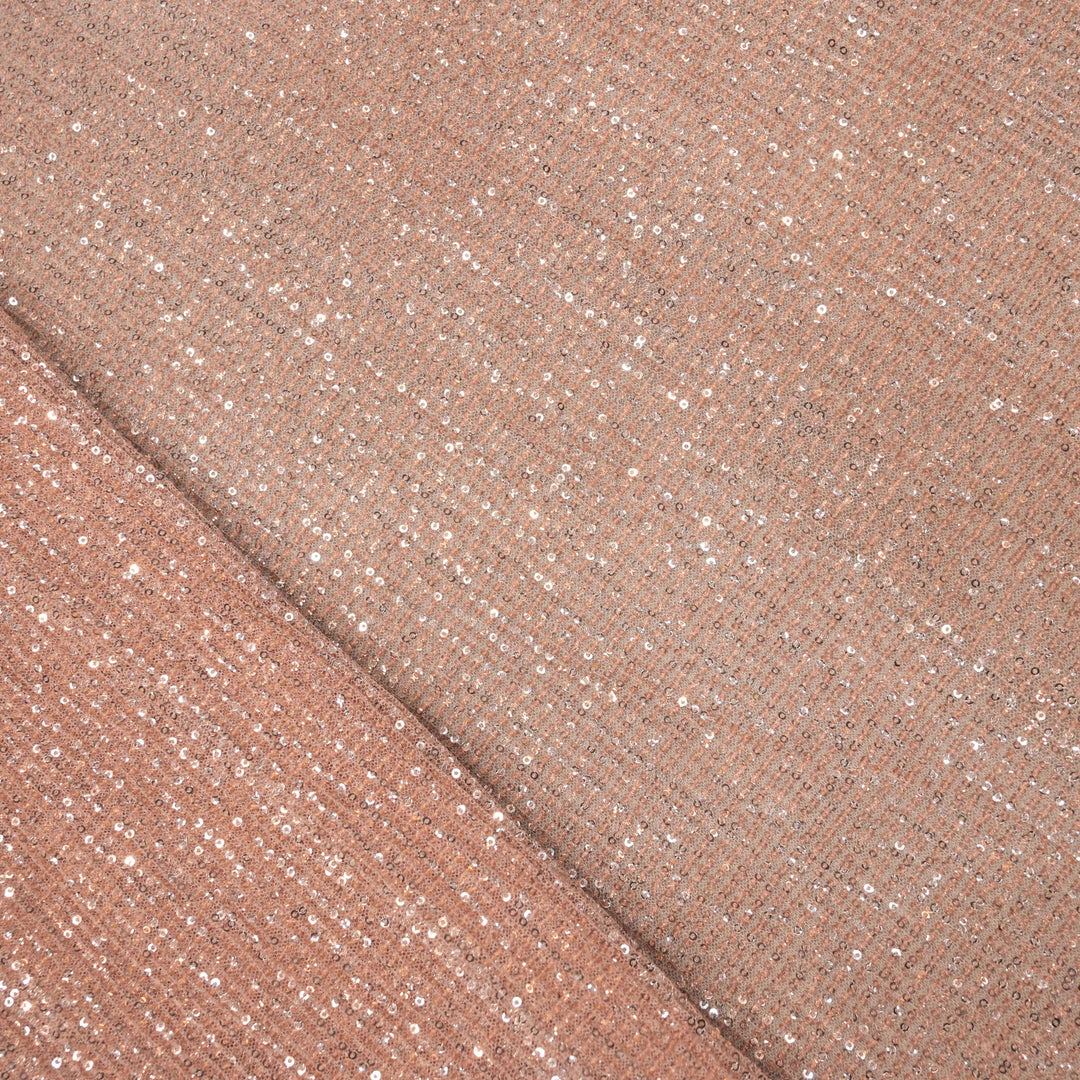 Close-up of a folded piece of rose gold glittery fabric.
